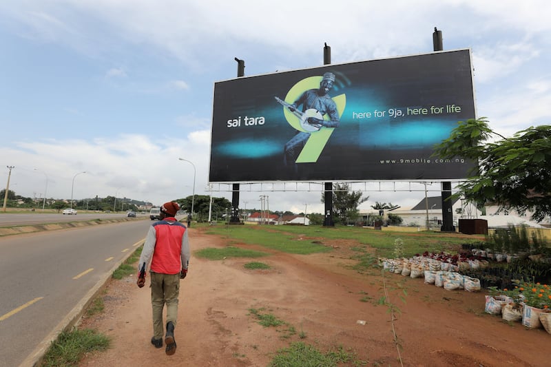 FILE PHOTO: A man walks towards a 9 Mobile telecom company outdoor billboard in Abuja, Nigeria, August 30, 2017. REUTERS/Afolabi Sotunde/File Photo