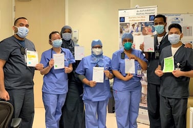 Abu Dhabi medical professionals hold up letters of appreciation they have received. Courtesy of SEHA