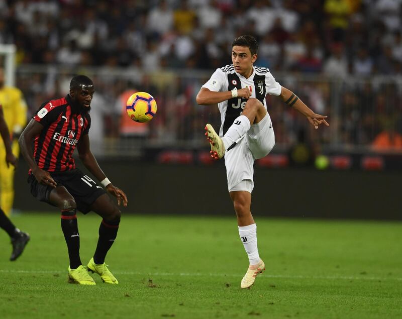 JEDDAH, SAUDI ARABIA - JANUARY 16: Paulo Dybala of Juventus controls the ball under pressure from Tiemoue Bakayoko of AC Milan during the Italian Supercup match between Juventus and AC Milan at King Abdullah Sports City on January 16, 2019 in Jeddah, Saudi Arabia. (Photo by Claudio Villa/Getty Images for Lega Serie A)