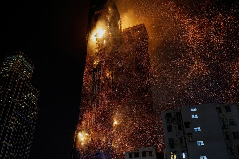 Sparks rain down on neighbouring streets as flames engulf the high-rise building in popular shopping district of Tsim Sha Tsui, in Hong Kong. Reuters