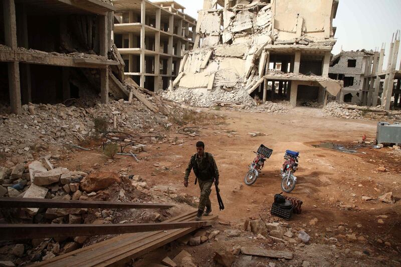 A Syrian rebel-fighter from the National Liberation Front (NLF) enters a building in the rebel-held al-Rashidin district of western Aleppo's countryside near Idlib province, on October 15, 2018. Jihadists in Syria's Idlib failed to meet a deadline to leave a planned buffer zone ringing the country's last rebel bastion, casting fresh doubt over a deal to avert bloodshed.  / AFP / Aaref WATAD
