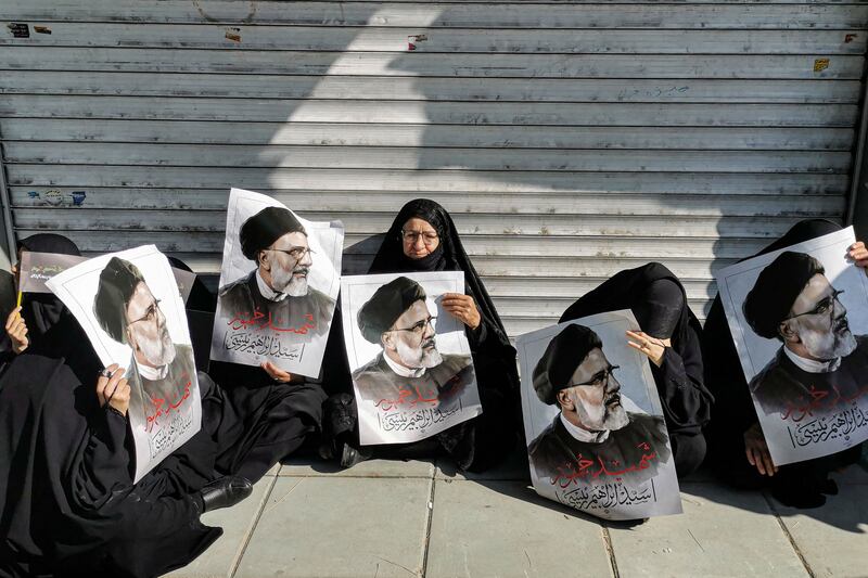 Women hold posters of Mr Raisi. The president, foreign minister Hossein Amirabdollahian and other top officials were killed in a helicopter crash on Sunday. AFP