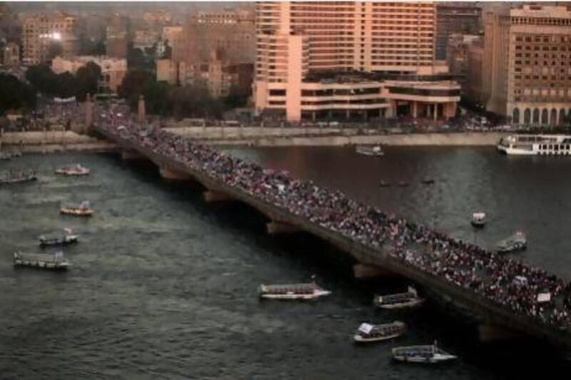 Supporters of Gen Abdel Fatah El Sisi march over a bridge towards Tahrir Square in Cairo yesterday. Nariman El Mofty / AP Photo