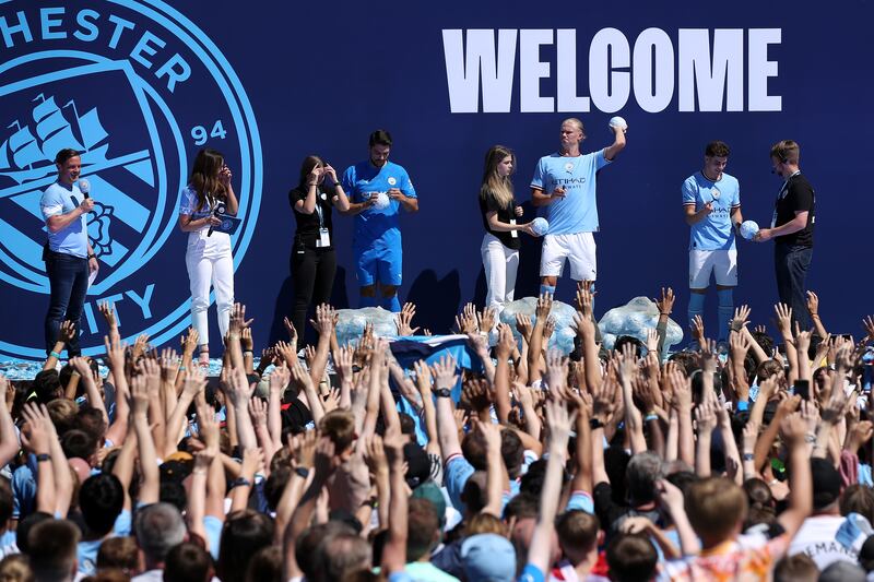 Stefan Ortega, Erling Haaland and Julian Alvarez of Manchester City throw shirts to the fans. Getty