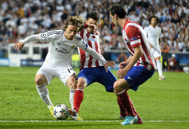 Real Madrid's Croatian midfielder Luka Modric (L) vies with Atletico's players during the UEFA Champions League Final Real Madrid vs Atletico de Madrid at Luz stadium in Lisbon, on May 24, 2014.   AFP PHOTO/ GERARD JULIEN (Photo by GERARD JULIEN / AFP)