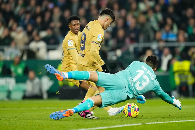 Betis goalkeeper Rui Silva makes a save from Barcelona's Pedri. AP