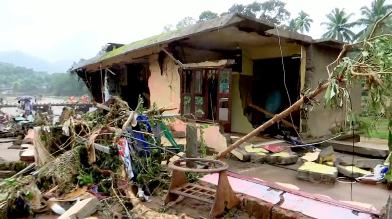 Trees and debris strewn outside a damaged house in Kottayam. Reuters