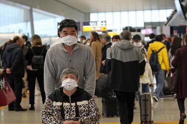 Chinese travellers wear face masks at Leonardo Da Vinci Airport amid concerns over the coronavirus outbreak. EPA    