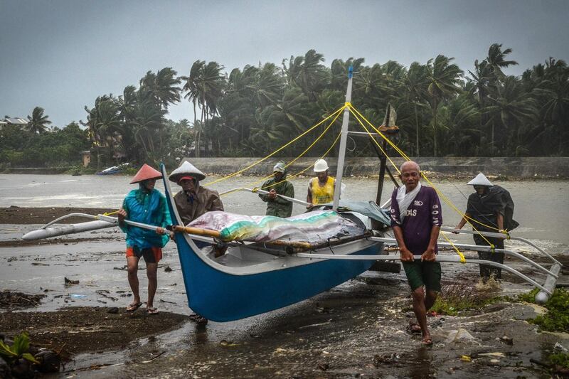 Fishermen carry a boat to higher ground in Baybay, eastern Samar after typhoon Phanfone hit the central Philippines.  AFP