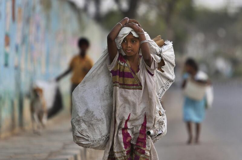 A girl walks with a bag used to collect recyclables in Hyderabad.  Mahesh Kumar A. / AP Photo