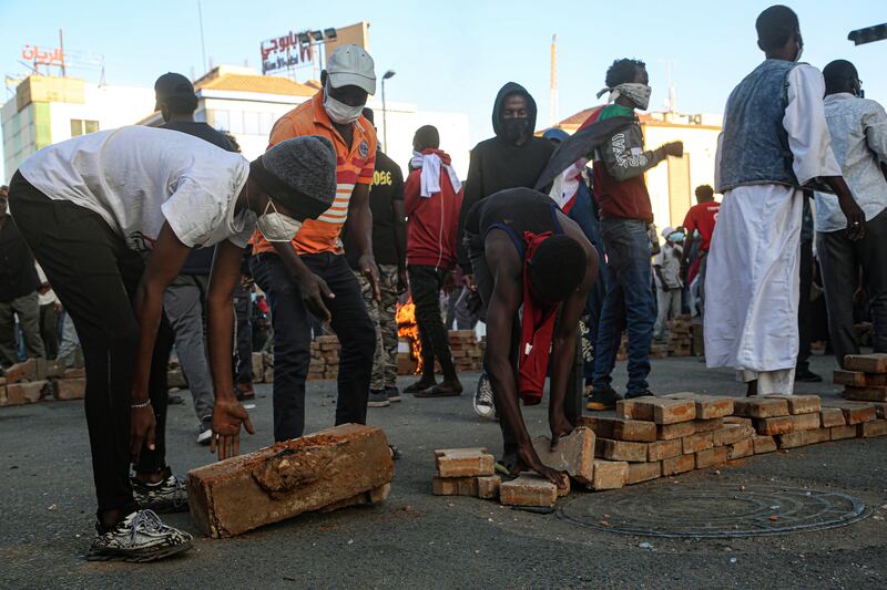 Protesters build a barricade on a street near the presidential palace in Khartoum.  EPA