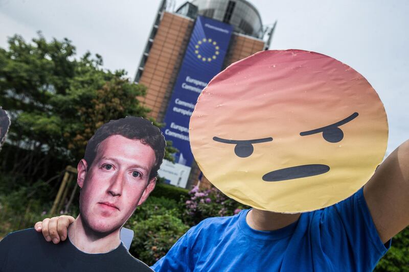 epa06755828 A member of the global citizens movement Avaaz stands next to life-sized Zuckerberg cutout figure, in a protest action in front of the European Commission in Brussels, Belgium, 22 May 2018. The action intends to highlight the hundreds of millions of fake Facebook accounts still spreading disinformation on the platform and to call on Facebook and EU legislators to take swift steps to defend democracies. Facebook CEO Mark Zuckerberg is to appear before the European Parliament  representatives on 22 May 2018 to answer questions in a live broadcast on data information breach by Cambridge Analytica and also how Facebook uses personal data in general.  EPA/STEPHANIE LECOCQ