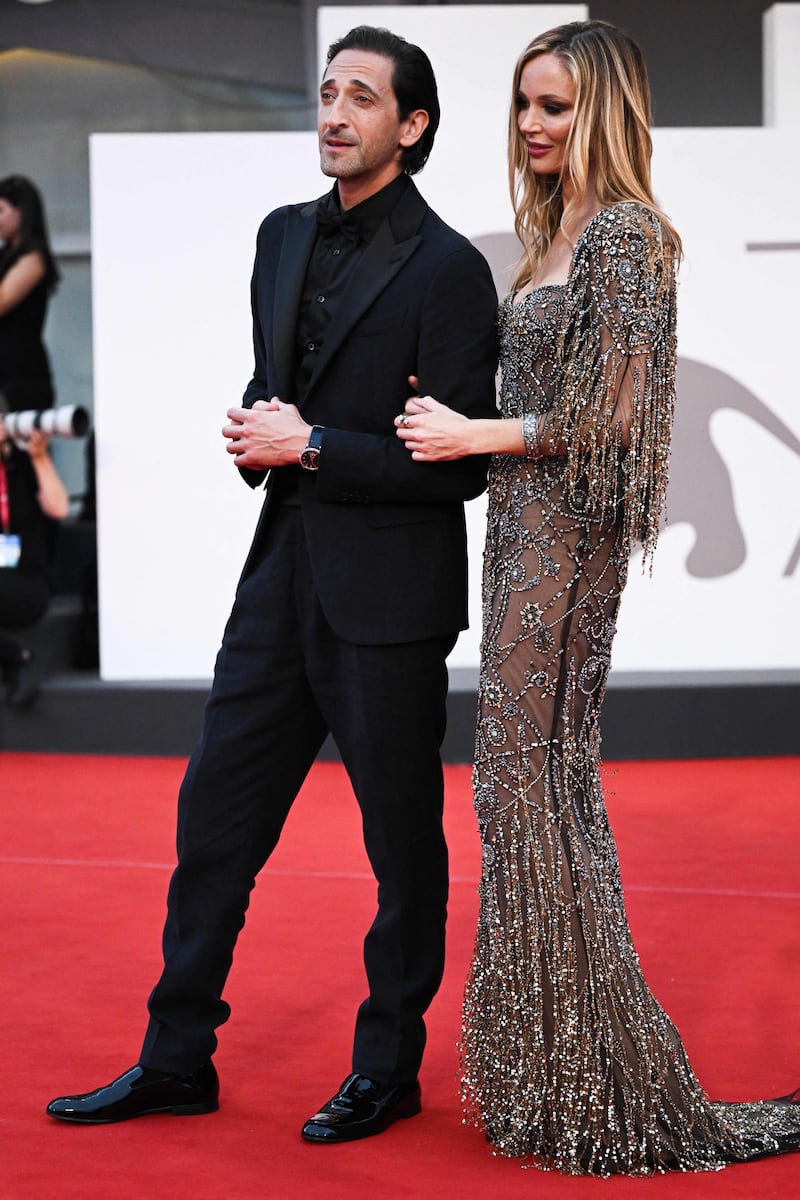 Adrien Brody, in all black, and British stylist Georgina Chapman, in a metallic gown. AFP