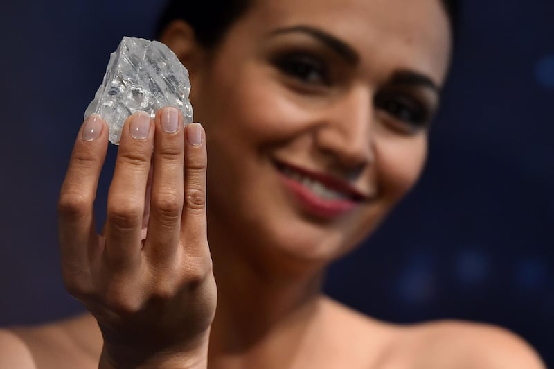 (FILES) This file photo taken on June 14, 2016 shows a model posing with an uncut 1109-carat diamond named 'Lesedi La Rona' at Sotheby's auction house in London.
Graff diamonds have purchased the Lesedi La Rona diamond on September 26, 2017 for $53 million from the Canadian mining company Lucara Diamond. / AFP PHOTO / BEN STANSALL