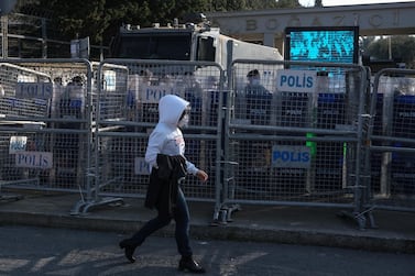 A student on their way to Bogazici University while Turkish riot police stand guard behind barricades. EPA