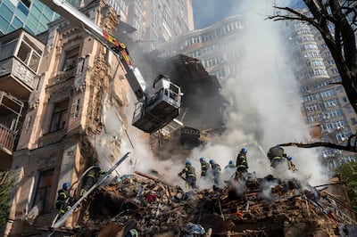 Firefighters work after a drone attack on buildings in Kyiv on October 17. AP