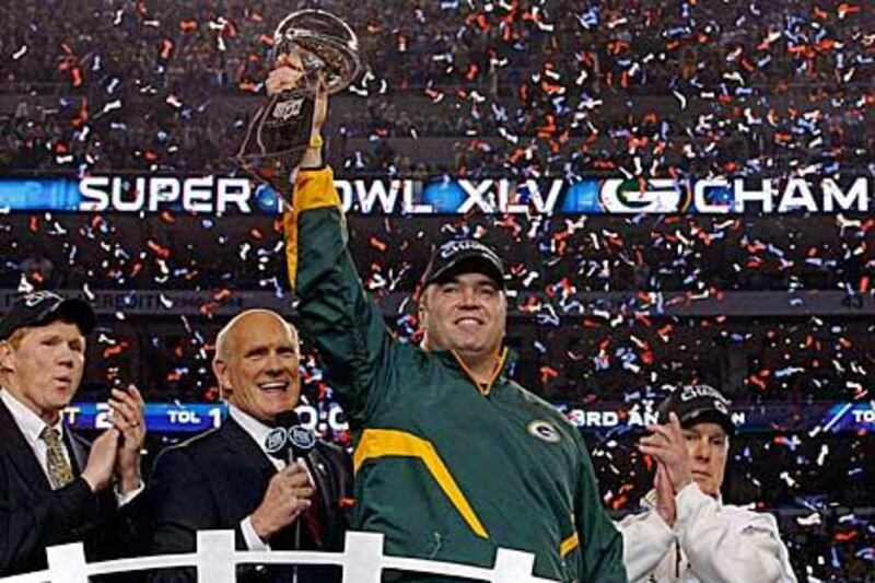 Green Bay Packers head coach Mike McCarthy holds up the Vince Lombardi Trophy.