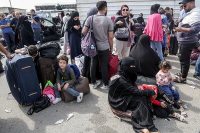 Palestinians with dual nationalities wait to cross the border from Gaza into Egypt at Rafah on Monday. EPA
