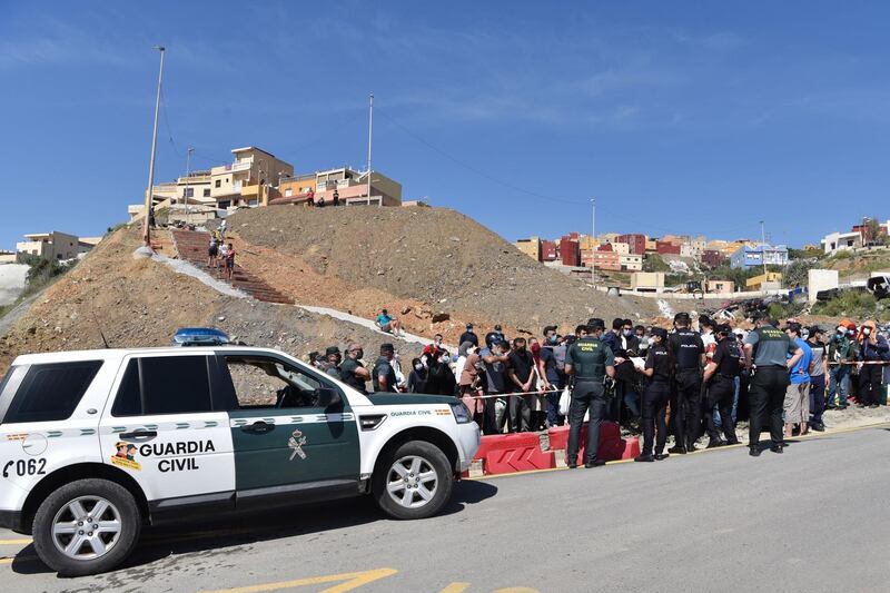 Moroccan citizens who will have to wait for their repatriation, after being stranded in Spain due to the coronavirus crisis, protest in front of police in the Spanish enclave of Ceuta. AFP