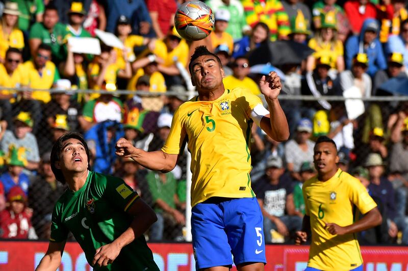 Brazil midfielder Casemiro heads the ball ahead of Bolivia's Marcelo Martins. Nelson Almeida / AFP