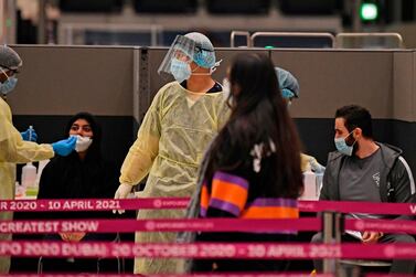 Health workers check passengers who arrived on an Emirates Airlines flight from London at Dubai International Airport amid the coronavirus pandemic. AFP