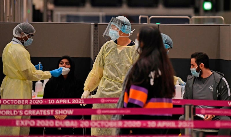 Health workers check passengers who arrived on an Emirates Airlines flight from London at   Dubai International Airport on May 8, 2020 amid the coronavirus Covid-19 pandemic.





   / AFP / Karim SAHIB
