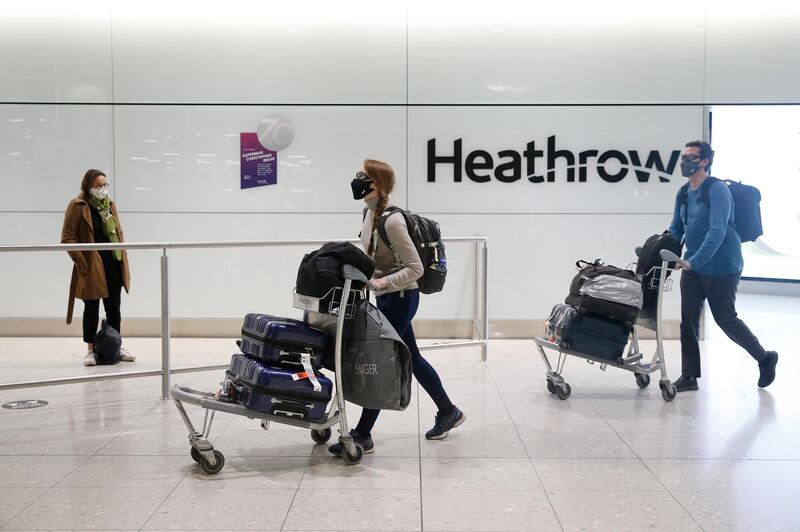 Travellers arrive at Heathrow Terminal 2 in London on January 30, after the UK added the UAE to the red list of countries banned from flying to Britain. British nationals and those with legitimate reasons to travel will be allowed into the UK but will be required to isolate for 10 days. Hollie Adams / Getty