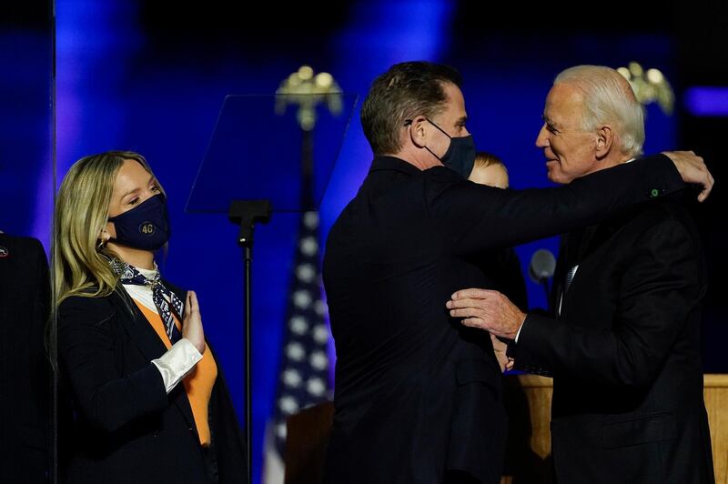 President-elect Joe Biden greets his son Hunter Biden and wife Melissa Cohen, left, as he holds his son, on stage with his family Saturday, Nov. 7, 2020, in Wilmington, Del. (AP Photo/Andrew Harnik)