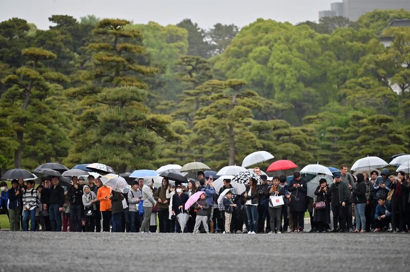 People gather outside the Imperial Palace, where the abdication ceremony for Japan's Emperor Akihito is taking place, in Tokyo.  Emperor Akihito is handing over the Chrysanthemum Throne to his eldest son, 59-year-old Crown Prince Naruhito, in a series of solemn rituals that also usher in the new imperial era named "Reiwa" -- meaning beautiful harmony -- that will last throughout the new monarch's reign.  AFP
