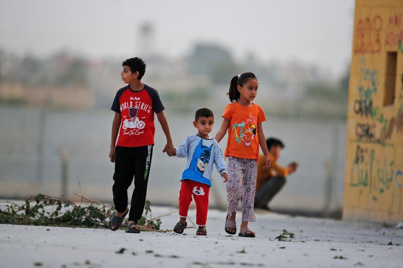 Children play at the border between Turkey and Syria, in Akcakale, Sanliurfa province, southeastern Turkey, Tuesday, Oct. 8, 2019. The Turkey - Syria border has became a hot spot as Turkish Vice President Fuat Oktay said Turkey was intent on combatting the threat of Syrian Kurdish fighters across its border in Syria. (AP Photo/Lefteris Pitarakis)