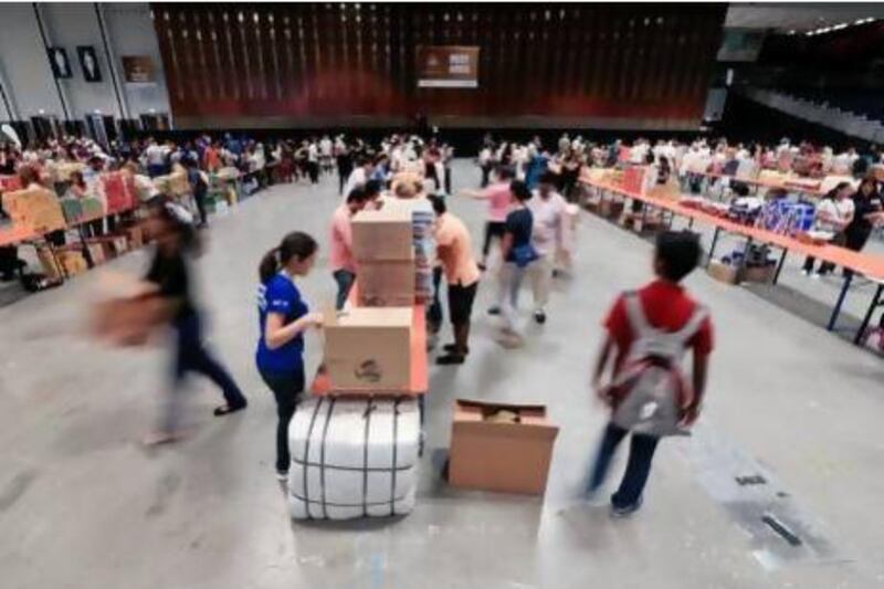 Volunteers for Adopt-a-Camp and Dubai Chamber of Commerce partnered to put together more than 5,000 Ramadan care packages for labourers as a part of Zayed Day for Humanitarian Work at Sheikh Rashid Hall at World Trade Centre yesterday. Sarah Dea / The National