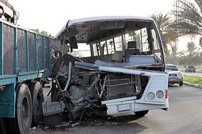 One person was killed and 14 were injured when a bus crashed into a lorry carrying bricks.