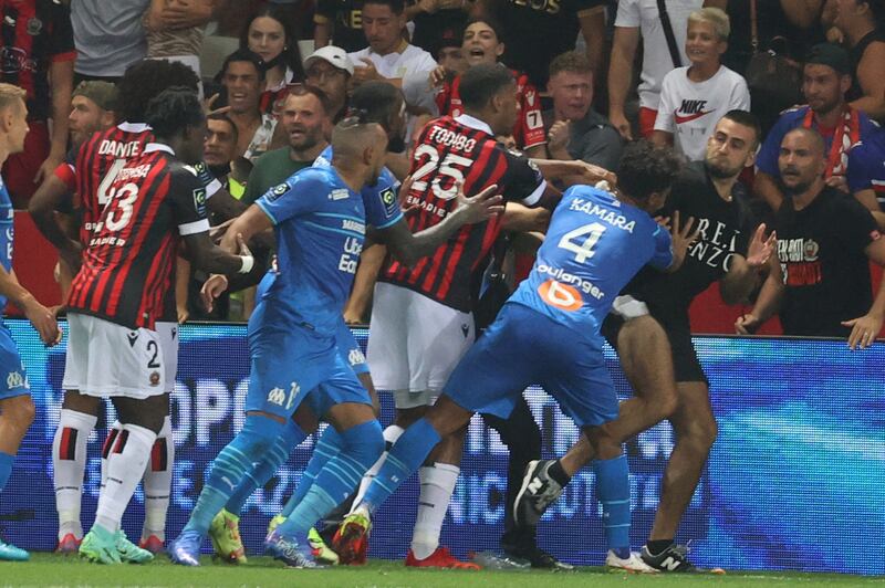 Fans try to invade the pitch during. AFP