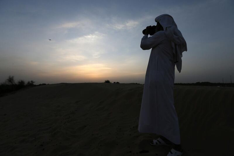 An astronomer looks out for the Ramadan crescent Moon from his binocular near Mushrif Park in Dubai. Pawan Singh / The National 