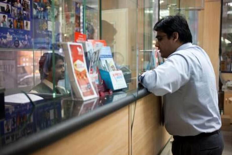 Dubai, United Arab Emirates - January 08 2013 - Customers at the Multinet Trust Exchange send remittances to their home countries at the Multinet branch in Deira. For story on how foreign exchanges dealing with the Pakistani government say they will not be imposing fees for money sent to Pakistan after the government began to payback overdue rebates. (Razan alzayani / The National)  