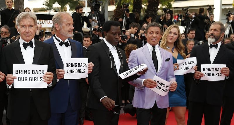 The cast of The Expendables 3, from left, Kelsey Grammer, Wesley Snipes, Sylvester Stallone, Ronda Rousey and Mel Gibson hold up banners reading, Bring Back Our Girls, part of a campaign calling for the release of nearly 300 abducted Nigerian schoolgirls being held by Nigerian Islamic extremist group Boko Haram, as they arrive for the screening of The Homesman at the 67th international film festival in Cannes, France on May 18, 2014. Alastair Grant / AP photo