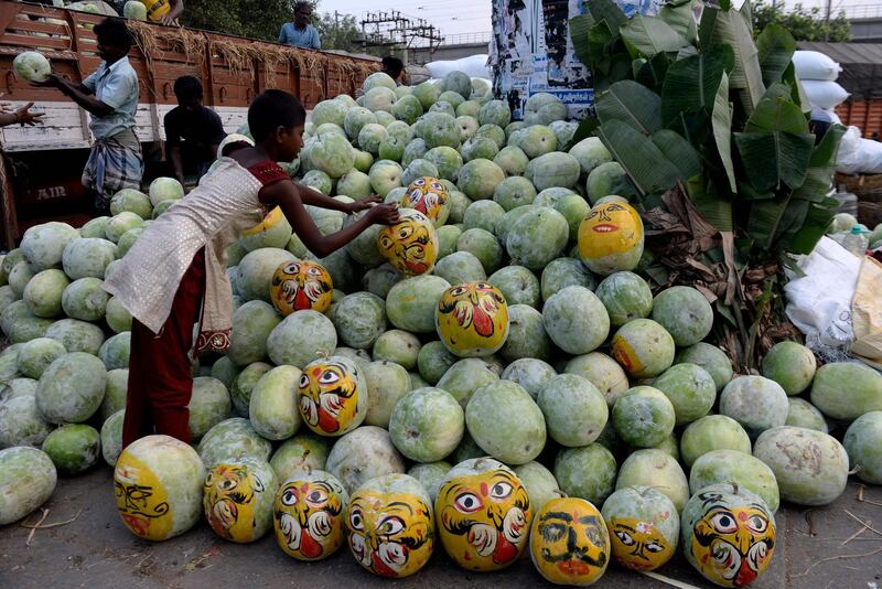 Indian vendors organise pumpkins painted to resemble demons during the Durga Puja festival in Chennai. AFP