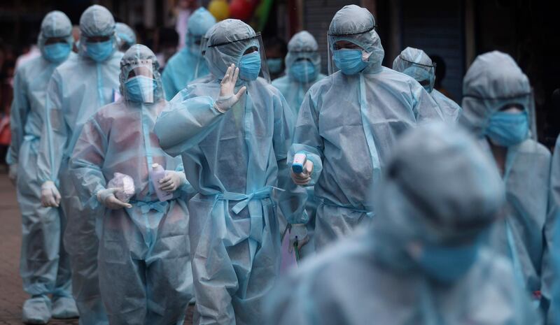 India health workers arrive to carry out check-ups in a slum in Mumbai. AP