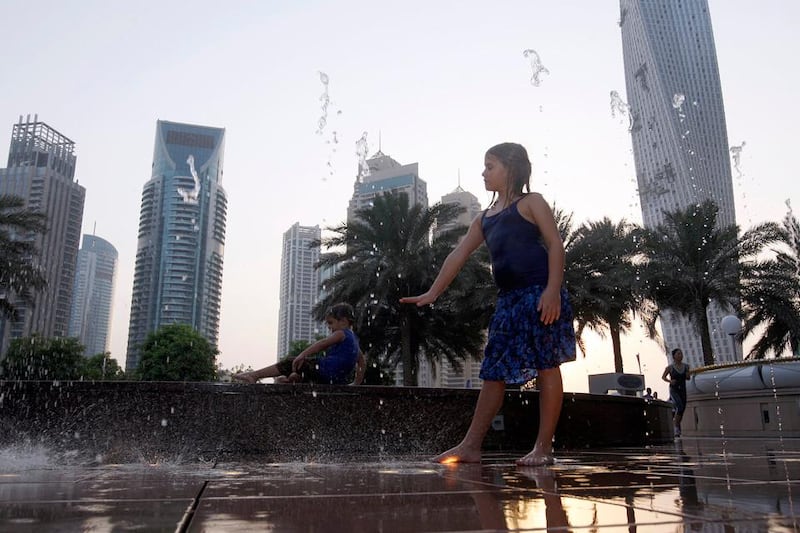 Dubai, United Arab Emirates, July 6 2012, Weather Stand alone for News Desk- (right) Lara Botha play in the foutain water at the Dubai Marina walk. Mike Young / The National