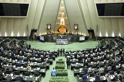 This handout picture provided by the Islamic Consultative Assembly News Agency (ICANA) on January 7, 2020 shows Iranian lawmakers raising their hands to vote during a parliamentary session in Tehran. - Iran's parliament passed a bill designating all US forces "terrorists" over the killing of a top Iranian military commander in a US strike last week. Under the newly adopted bill, all US forces and employees of the Pentagon and affiliated organisations, agents and commanders and those who ordered the "martyrdom" of Soleimani were designated as "terrorists". (Photo by - / ICANA NEWS AGENCY / AFP)