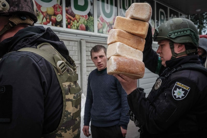 Police officers deliver loaves of bread to residents in the eastern Ukrainian city of Lyman, which is being heavily shelled. AFP
