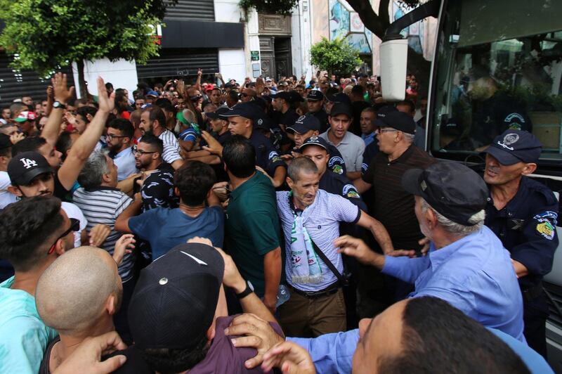 Police officers stand guard as demonstrators try to force their way during a protest rejecting Algerian election announcement for December, in Algiers, Algeria. REUTERS