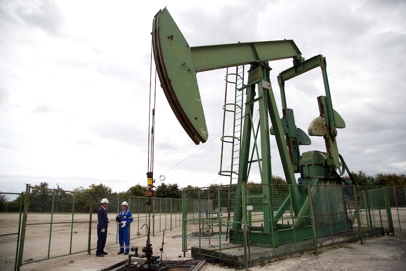 Thierry Oger, right, a production manager for Canadian based Vermilion oil company, and Jean-Pascal Simard, head of public affairs, warcht an oil rig, Wednesday, Sept. 6, 2017 in Andrezel, south east of Paris . France's government has unveiled a law to ban all production and exploration of oil and natural gas by 2040 on the country's mainland and overseas territories. The move is largely symbolic, however, as France's oil and gas production represents just 1 percent of national consumption _ the rest is imported. (AP Photo/Thibault Camus)