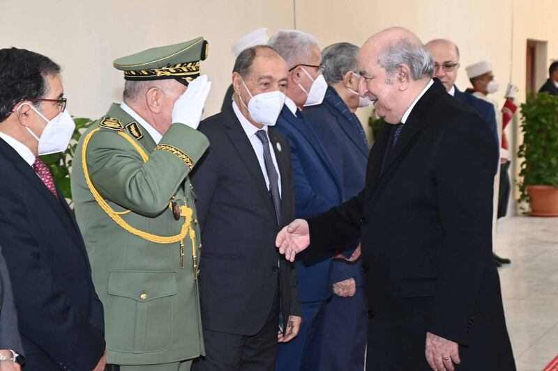 Mr Tebboune, right, greets officials at a meeting of senior figures and local governors at the Palace of Nations in Algiers