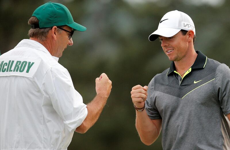 FILE PHOTO - Rory McIlroy of Northern Ireland bumps fists with his caddie J.P. Fitzgerald after making a birdie on the 18th hole during second round play of the Masters golf tournament at the Augusta National Golf Course in Augusta, Georgia April 10, 2015.  REUTERS/Brian Snyder/File Photo