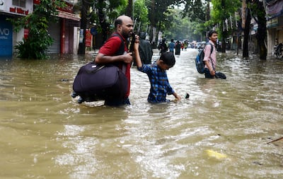 Indians wade through a flooded street during heavy rain showers in Mumbai on August 29, 2017.
Heavy rain brought India's financial capital Mumbai to a virtual standstill on August 29, flooding streets, causing transport chaos and prompting warnings to stay indoors. Dozens of flights and local train services were cancelled as rains lashed the coastal city of nearly 20 million people.
 / AFP PHOTO / PUNIT PARANJPE