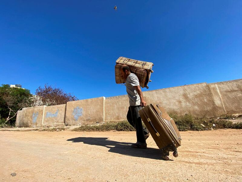 A man carries his belongings, in the aftermath of floods in Derna. Reuters