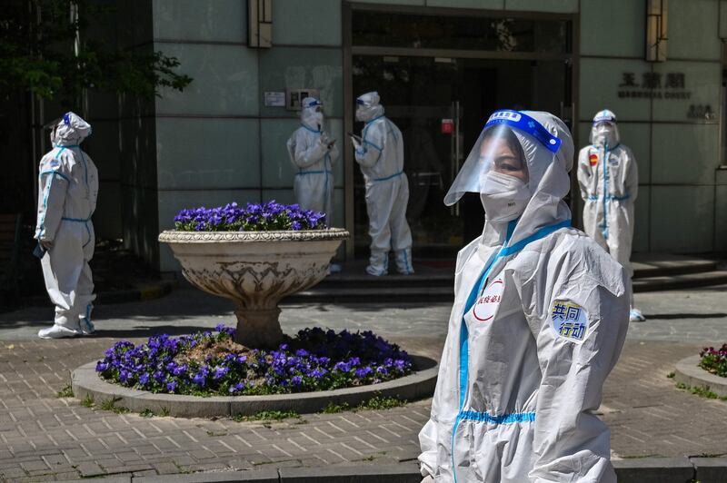 Medical workers and volunteers in a compound where residents are being tested for Covid-19. AFP