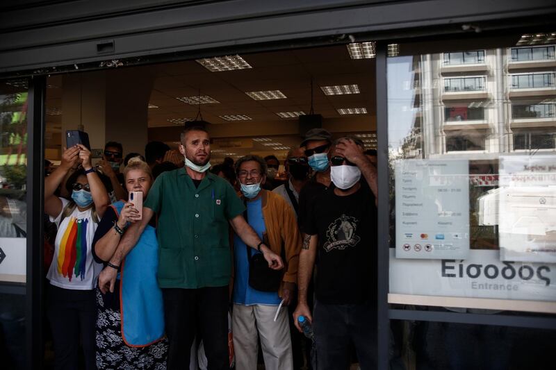 Customers protect themselves from tear gas inside a supermarket. EPA