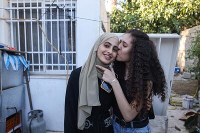 A relative kisses Palestinian activist Mona el-Kurd, 23, as she arrives home after being released from a police station in Israeli-annexed east Jerusalem, on June 6, 2021. Israeli police arrested the prominent activist who campaigns against the threatened expulsion of Palestinian families from homes in the Israeli-annexed east Jerusalem neighbourhood of Sheikh Jarrah, and left a summons for her twin brother, Muhammad, their father told AFP a day after police had also detained an Al Jazeera journalist covering a demonstration nearby. / AFP / AHMAD GHARABLI
